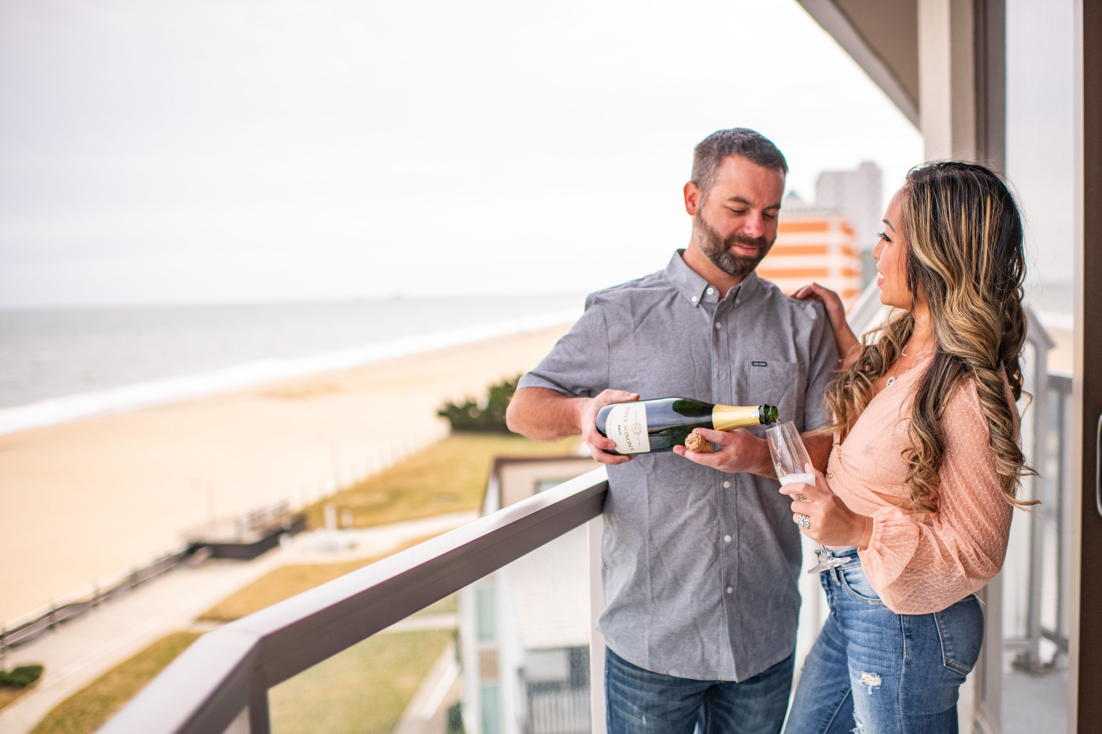 A balcony with a view of the beach and ocean.
