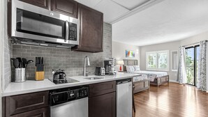 A modern kitchen with stainless steel appliances, a dishwasher, and a coffee maker. - 1407 - Universal Studios View (Orlando)
