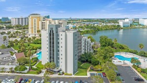 A high-rise hotel with multiple floors, a swimming pool, and a view of a lake. - 1407 - Universal Studios View (Orlando)