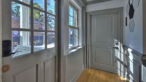 A hallway with a white door, large windows, and a view of the street outside. - Modern Penthouse Suite in historic downtown Blue Ridge, GA (Blue Ridge)