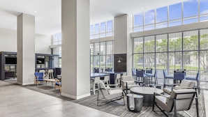Un espacio interior amplio con techos altos, ventanas grandes y mobiliario moderno.