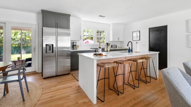 A modern kitchen with a central island, stainless steel appliances, and a dining area with a table and chairs. - Beautiful Backyard! | Angel Oak in Park Circle (North Charleston)