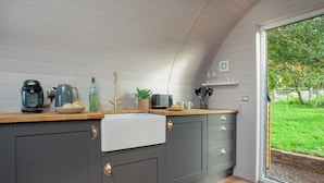 Een moderne keuken met een inbouwoven, een koffiezetapparaat en een spoelbak.
