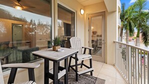 Ein Balkon mit Tisch, Stühlen und einem Blumentopf.