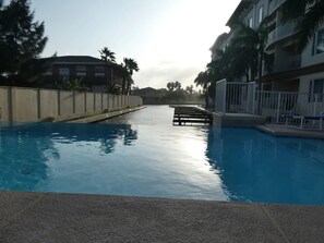 Relax by the serene pool surrounded by a low wall and scenic views.