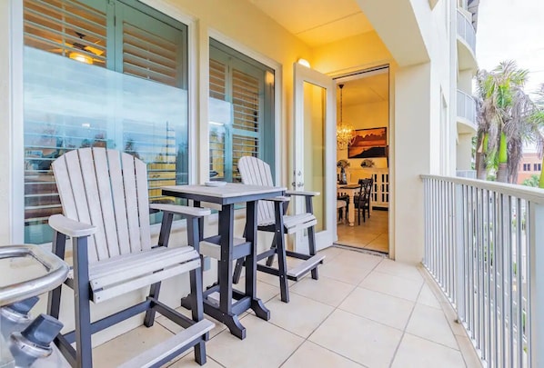 Relax with friends and family in this inviting balcony area, featuring a dining table and four Adirondack chairs.