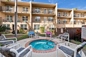 A residential building with a swimming pool, outdoor seating, and a fenced patio area. - Relaxed Island Escape with Pool and Hot Tub Access (South Padre Island)