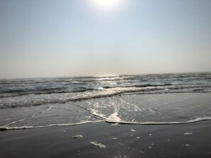 A beach with waves and a clear sky.
