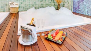 A spa area with a hot tub, a fruit platter, a champagne bottle, and glasses. - Doubletree by Hilton Foz do Iguacu (Foz do Iguaçu)