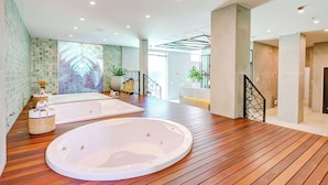 A spacious bathroom with two large tubs, a wooden floor, and a green-tiled wall. - Doubletree by Hilton Foz do Iguacu (Foz do Iguaçu)