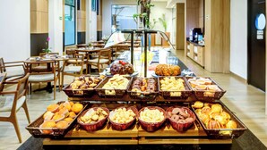 A buffet with various food items and a central decorative vase. - Doubletree by Hilton Foz do Iguacu (Foz do Iguaçu)
