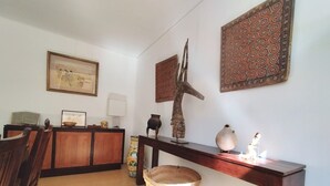 A dining area with a wooden table, chairs, and a decorative wall piece.