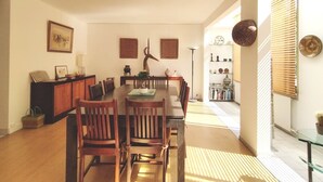 A dining area with a wooden table and chairs, a cabinet, and decorative items on the walls.