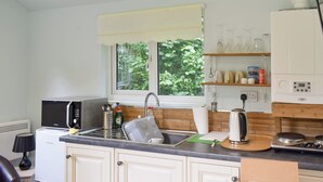 A compact kitchen with a microwave, sink, and stove.