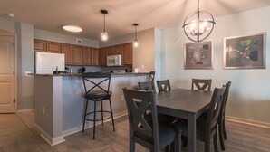 Une cuisine moderne avec des meubles en bois, un îlot central et des luminaires suspendus.