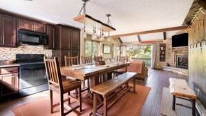 A spacious kitchen with dark wooden cabinets, a large wooden dining table, and a built-in oven. - Your Four-Season Escape at Camelback Mountain
Townhouse Sleeps 10 comfortably. (Tannersville)