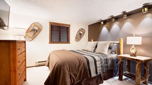 A bedroom with a bed, wooden dresser, wall-mounted lamps, and a window with blinds. - Your Four-Season Escape at Camelback Mountain
Townhouse Sleeps 10 comfortably. (Tannersville)