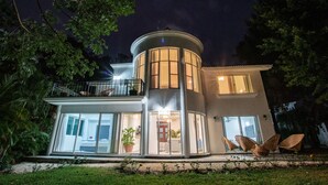 A modern house with a curved tower, large windows, and outdoor seating. - Big family? This is the perfect place, a giant villa close to the beach! (Playa del Carmen)