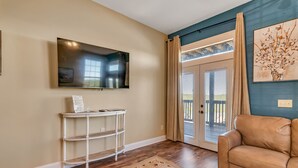 A living room with a TV mounted on the wall, a white console table, a brown leather sofa, and a patterned rug. - Large Family Alert-Walk-In Lakeview-Sleeps 9-Pools-Near Silver Dollar City (Branson)