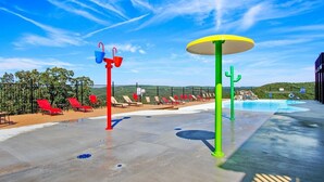 A pool area with red and green water features, sun loungers, and a clear blue sky. - Large Family Alert-Walk-In Lakeview-Sleeps 9-Pools-Near Silver Dollar City (Branson)