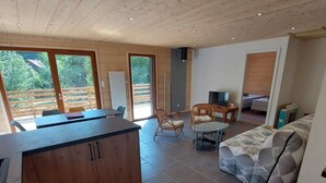 Een moderne woonkamer met een bank, een eettafel en een keuken met een groot schiereiland.
