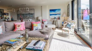 Un salon moderne avec un canapé, une table basse et une vue sur l’extérieur.