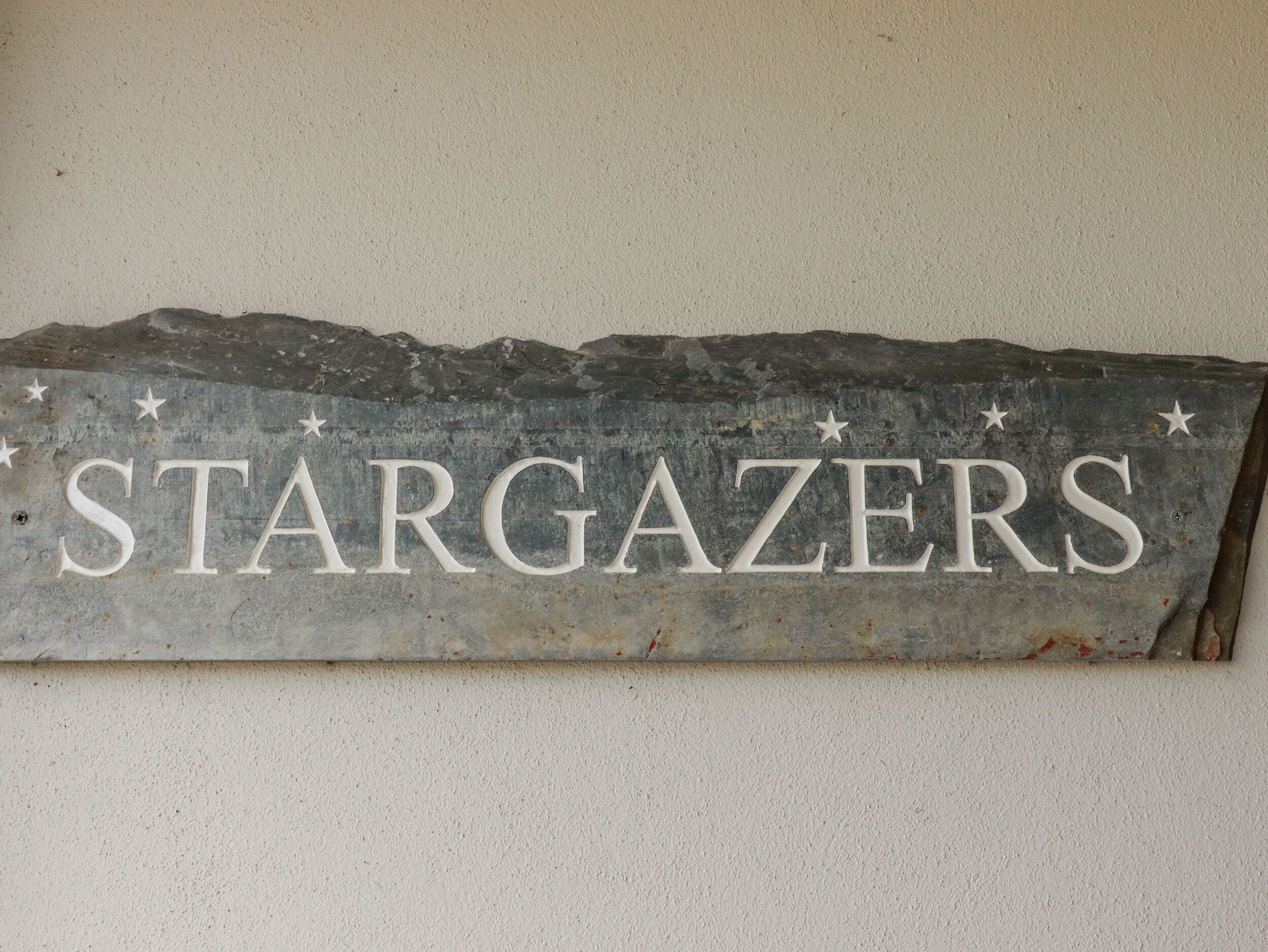A stone sign with the word "STARGAZERS" and decorative stars.
