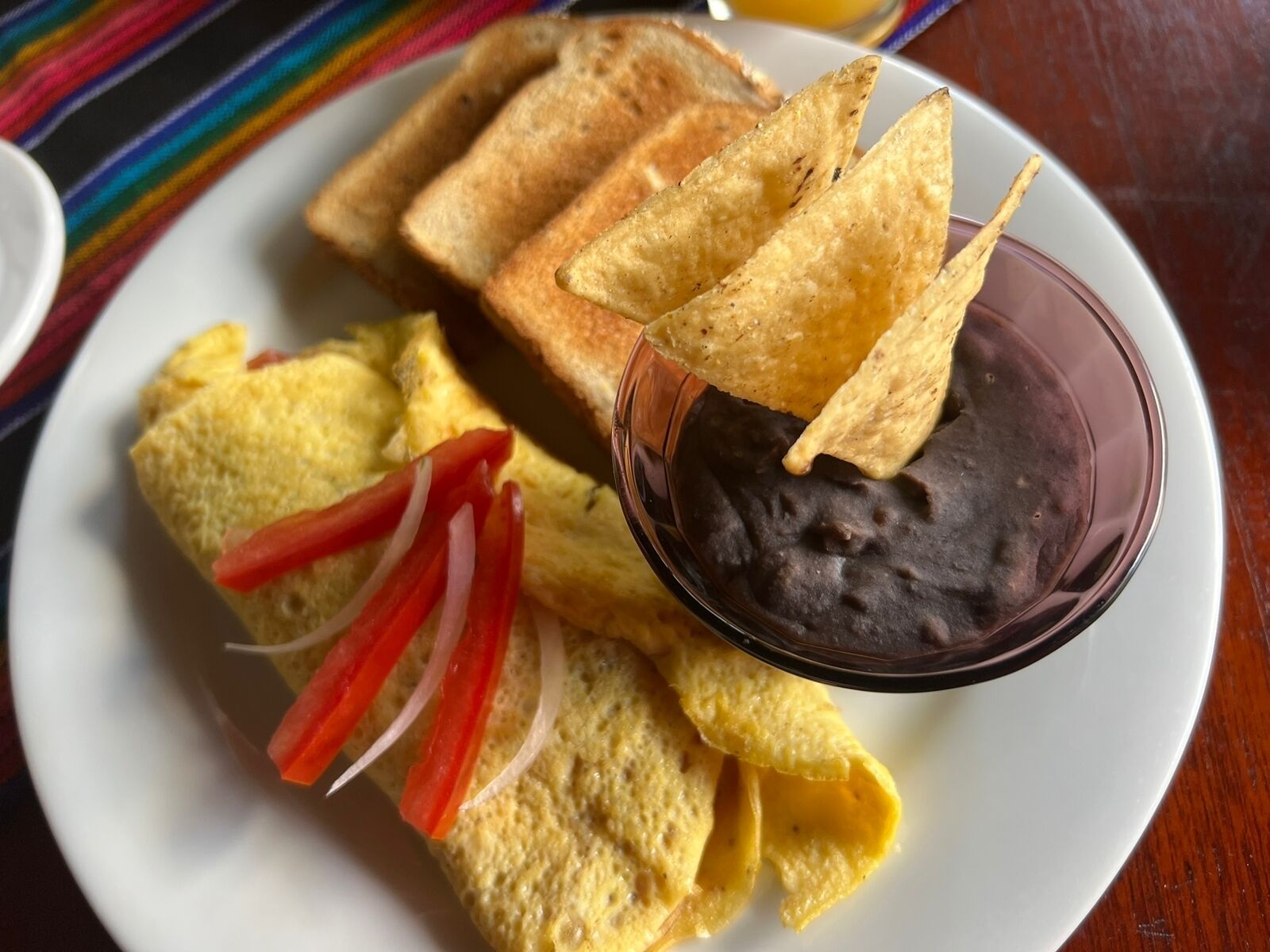 A plate with tostadas, refried beans, and sliced onions.
