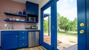 Een moderne keuken met blauwe kastjes, een roestvrijstalen koelkast en een magnetron.