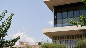 A modern building with large windows and a balcony, overlooking ancient ruins. - Sleeping with the Ancient Gods in Koukaki (Athina)