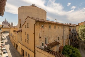 A historic building with a cylindrical tower, multiple windows, and a fire escape. - Discover Florence and feel right at home (Firenze)