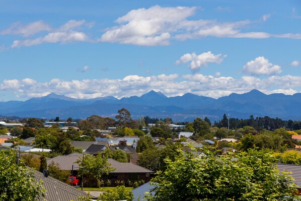 A residential area with houses, trees, and mountains in the background. - Views over Blenheim - Blenheim Holiday Home (Blenheim)
