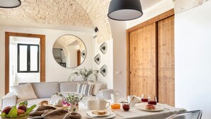 A breakfast setup with a table, chairs, and a bowl of fruit. - Beautifull Villa with Trullo (Ostuni)