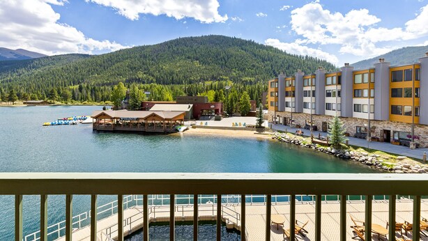 Hotel na beira do lago com píer, piscina ao ar livre e vista para as montanhas.