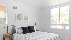 A bedroom with a bed, two bedside tables, two lamps, and two framed artworks on the wall. - Brand new house next to Downtown Los Angeles (Los Angeles)