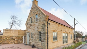 A stone house with a red-tiled roof, a brick driveway, and a wooden fence. - 3 bedroom accommodation in Scaling Dam, near Whitby (Scaling Dam, near Whitby)