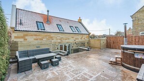 A stone building with a tiled roof, a wooden fence, and outdoor seating. - 3 bedroom accommodation in Scaling Dam, near Whitby (Scaling Dam, near Whitby)