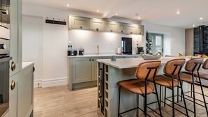 A modern kitchen with a central island, bar stools, and a built-in stove. - 3 bedroom accommodation in Scaling Dam, near Whitby (Scaling Dam, near Whitby)
