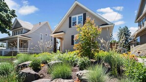 Une maison d’habitation dotée d’un jardin aménagé avec des rochers et différentes espèces de plantes.