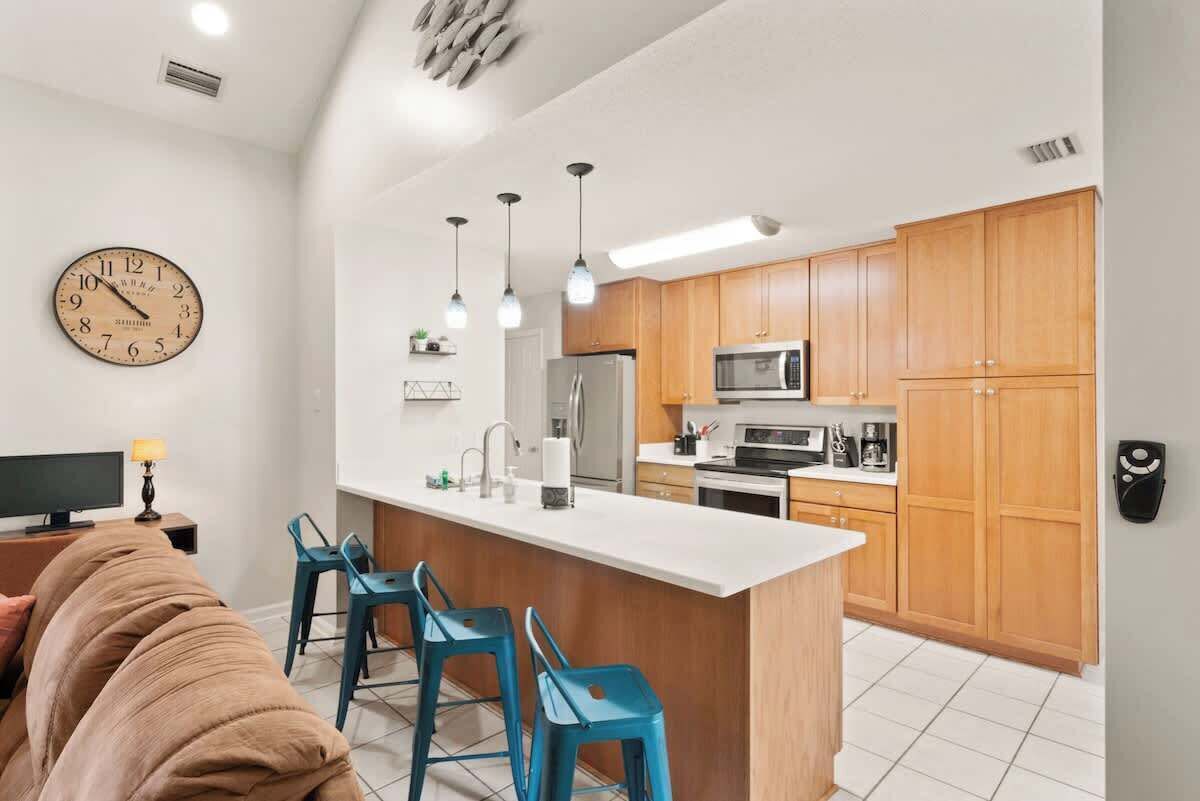 Une cuisine moderne avec des meubles en bois, un îlot central et des luminaires suspendus.