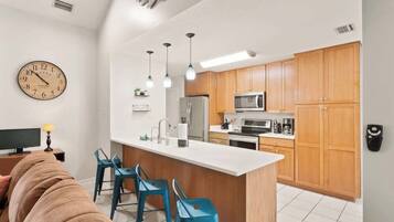 Une cuisine moderne avec des meubles en bois, un îlot central et des luminaires suspendus.