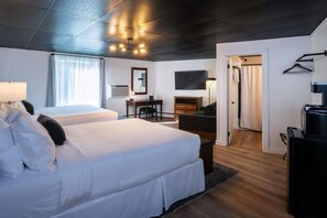 Una habitación de hotel con dos camas, un escritorio, televisión y armario.