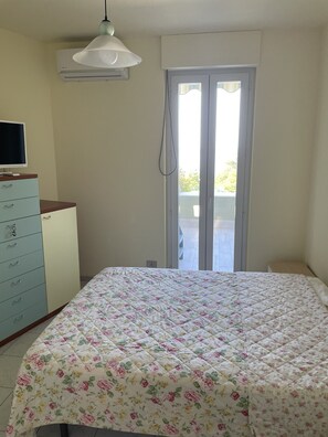 Une chambre à coucher comprenant un lit, une commode et un appareil de climatisation.