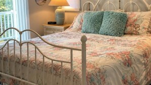 A bedroom with a bed, a nightstand, a lamp, and a painting on the wall. - Cozy home in quiet neighborhood!! LLC.              2 Kings  bed and 1 Queen  (Spring Hill)