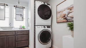 A compact laundry area with a front-loading washer and dryer, a sink, and a mirror. - Family & dog friendly; 5 min walk to beach, bars, downtown, restaurants and park (Detroit Lakes)