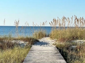 A wooden boardwalk leading to a beach with tall grasses and a clear blue sky. - Escape to The Cape at Villa Azul (Gulf County)