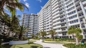A modern multi-story hotel with a central courtyard surrounded by lush greenery and palm trees. - Romantic-Stunning-Ocean view-Balcony-Panoramic-Amazing Sunrise-Miami-South-Beach (Miami Beach)
