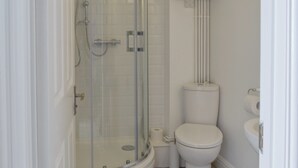 A bathroom with a glass-enclosed shower, a toilet, and a sink. - 2 bedroom accommodation in Sandgate (Sandgate)