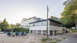 Un bâtiment situé en bord de mer, doté d’une terrasse avec des places assises et d’un escalier menant à une plateforme.