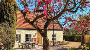 A stone cottage with a tiled roof, a wooden door, and a sign reading "Baker's Cottage." - 3 bedroom accommodation in Hotham, near Beverley (Hotham, near Beverley)